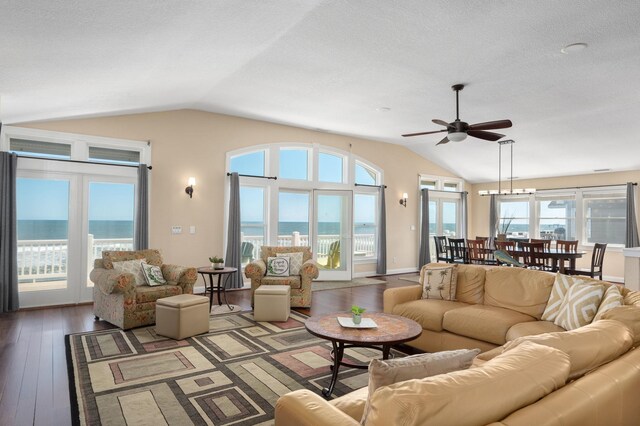 living area with vaulted ceiling, hardwood / wood-style floors, and a water view