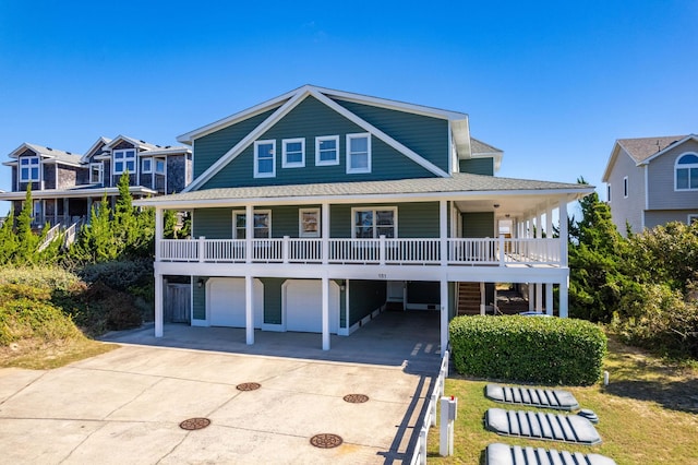 view of front of property featuring a porch, driveway, roof with shingles, and a garage