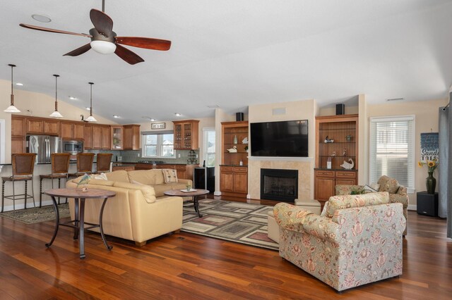 living area with dark wood-style floors, lofted ceiling, and plenty of natural light