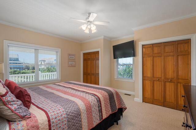 bedroom with ornamental molding, light colored carpet, visible vents, and baseboards