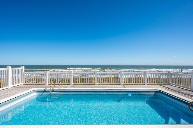 view of swimming pool featuring a water view, fence, and a fenced in pool