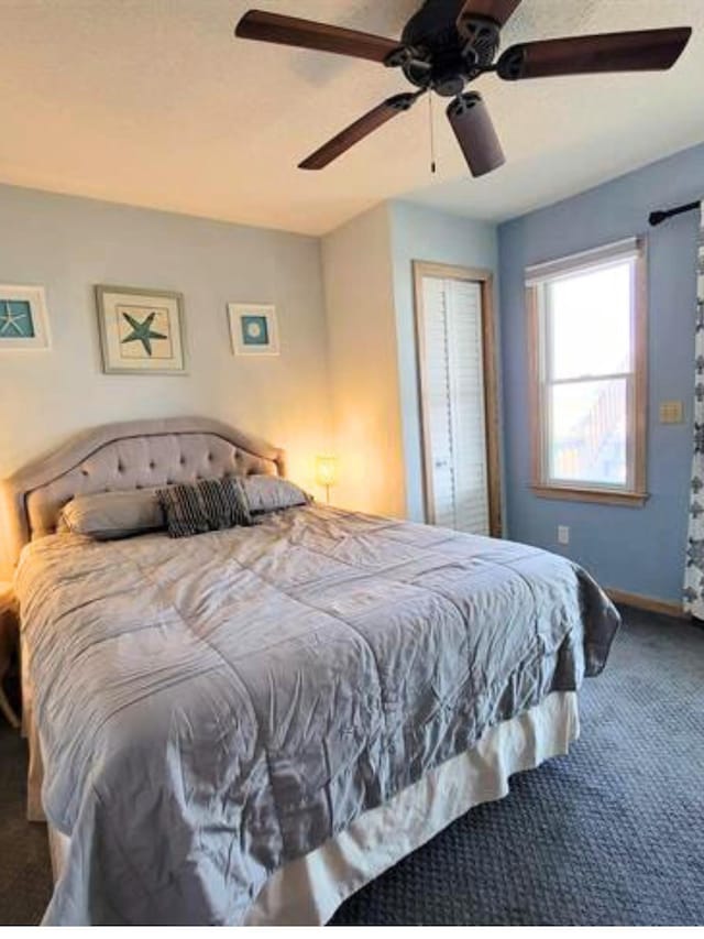 bedroom with a ceiling fan, a closet, carpet flooring, and baseboards