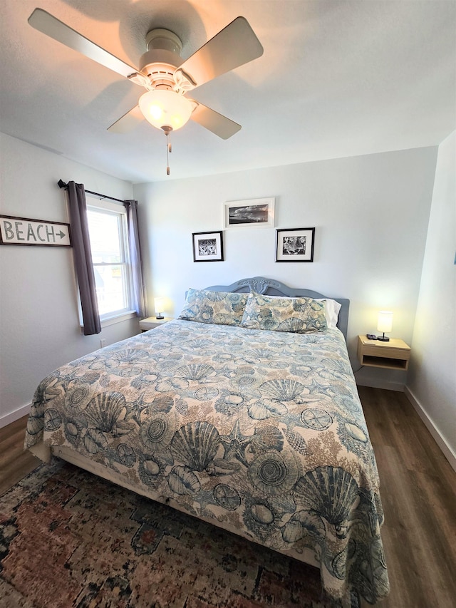 bedroom featuring dark wood-style floors, a ceiling fan, and baseboards