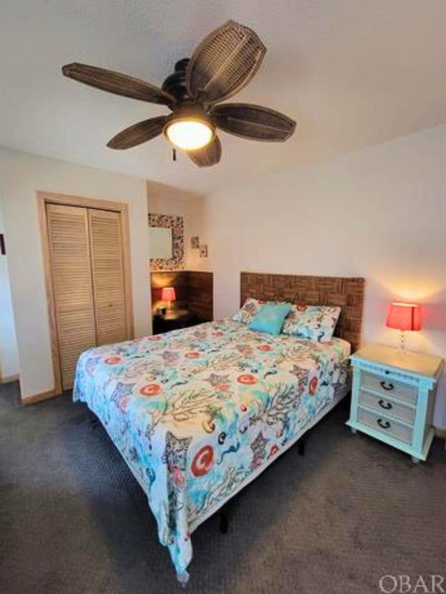 bedroom featuring ceiling fan, dark carpet, and a closet