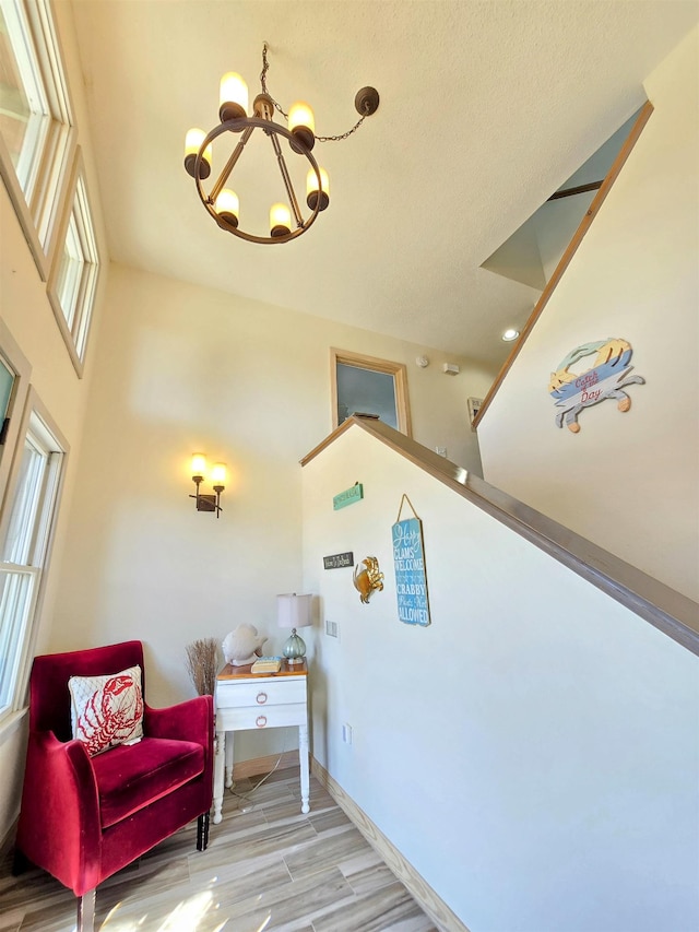 interior space with baseboards, light wood finished floors, and an inviting chandelier