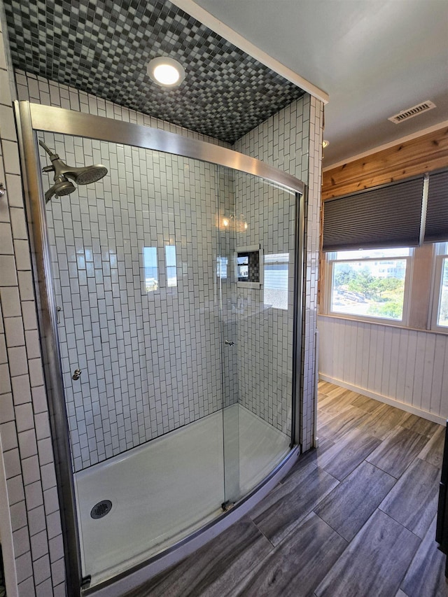 full bath featuring a stall shower, wood finished floors, and visible vents