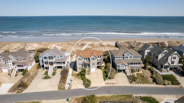 drone / aerial view featuring a beach view, a water view, and a residential view