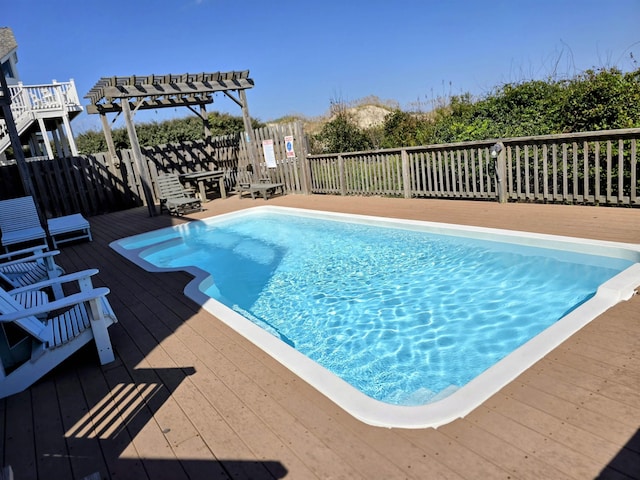 view of swimming pool featuring a deck, a fenced in pool, and a pergola