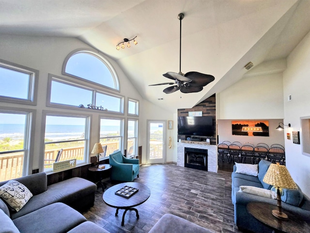 living area featuring dark wood-type flooring, a ceiling fan, visible vents, and a healthy amount of sunlight