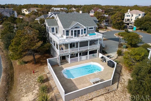 rear view of house featuring a patio, a residential view, fence, and a balcony