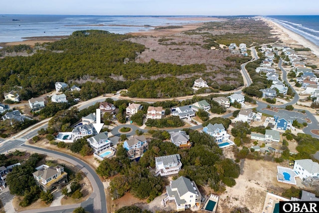 drone / aerial view featuring a view of the beach, a residential view, and a water view