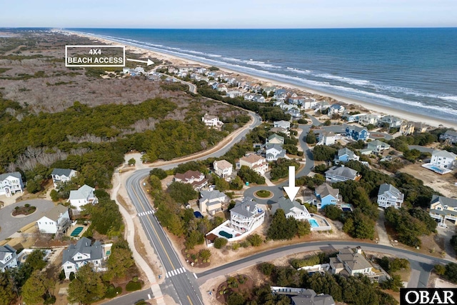 drone / aerial view with a water view, a residential view, and a view of the beach