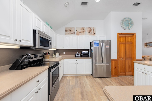 kitchen with stainless steel appliances, light countertops, and white cabinetry