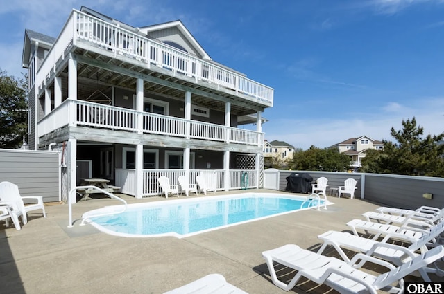 rear view of property with a fenced in pool, a patio area, and fence