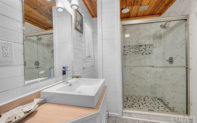 bathroom with a stall shower, wood ceiling, and vanity