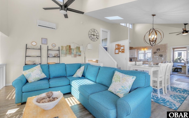 living area featuring high vaulted ceiling, ceiling fan with notable chandelier, light wood-style floors, stairs, and a wall mounted air conditioner