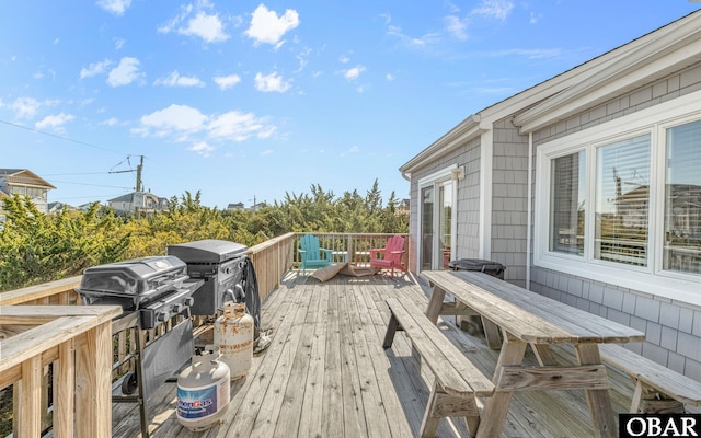 wooden deck with outdoor dining space and grilling area