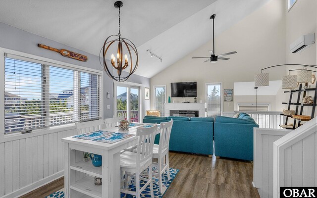 25056 Sea Vista Ct Lot 29, Waves, NC 27982 - dining space featuring dark wood-style floors, an AC wall unit, ceiling fan with notable chandelier, and a glass covered fireplace
