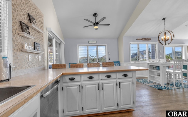 kitchen with a peninsula, white cabinetry, light countertops, and stainless steel dishwasher