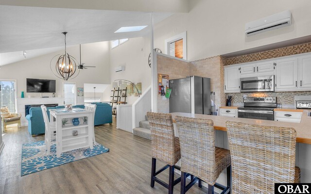 25056 Sea Vista Ct Lot 29, Waves, NC 27982 - kitchen featuring white cabinets, open floor plan, decorative light fixtures, stainless steel appliances, and a wall mounted AC