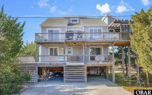 view of front facade featuring driveway, covered porch, and a carport