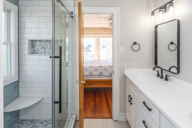 full bath with double vanity, a shower stall, a sink, and ensuite bathroom