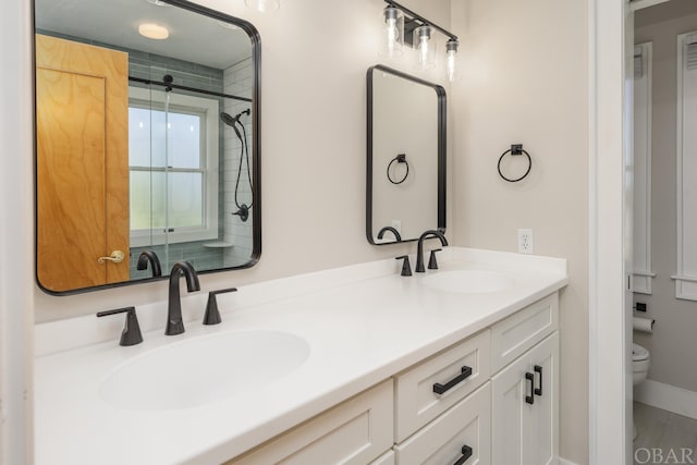 full bathroom with a shower with door, a sink, toilet, and double vanity