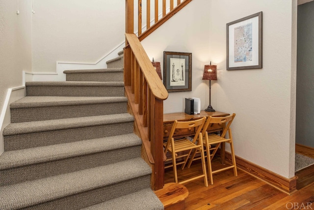 stairway with baseboards and wood finished floors