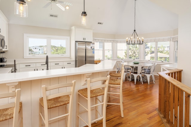 1229 Ocean Hill Ct Lot 120, Corolla, NC 27927 - kitchen with stainless steel appliances, light countertops, light wood-style flooring, white cabinetry, and hanging light fixtures