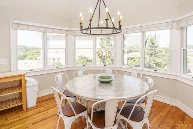 dining room with a chandelier, light wood-type flooring, and baseboards