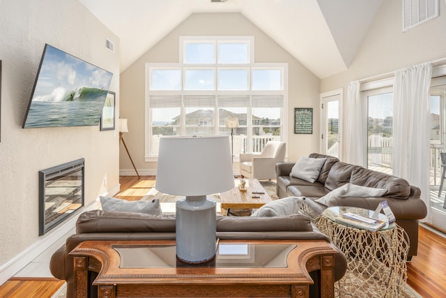 1229 Ocean Hill Ct Lot 120, Corolla, NC 27927 - living area featuring wood finished floors, healthy amount of natural light, baseboards, and high vaulted ceiling