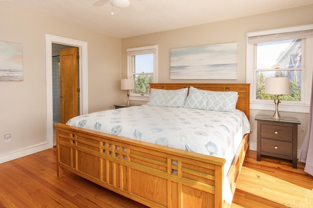 bedroom with a ceiling fan, light wood-type flooring, and baseboards