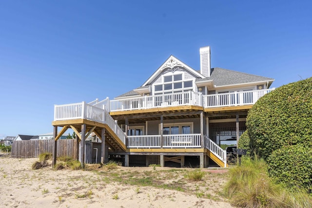 1229 Ocean Hill Ct Lot 120, Corolla, NC 27927 - back of property featuring stairway, a wooden deck, a chimney, fence, and roof with shingles