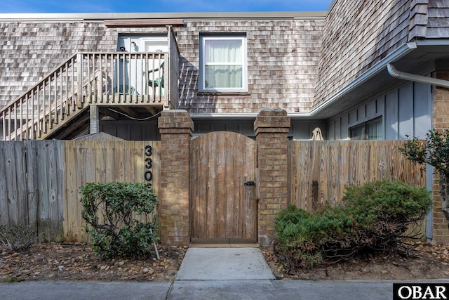 view of front facade with mansard roof, fence private yard, and a gate