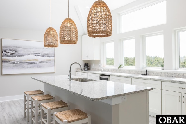 2267 Sandpiper Rd Lot 29, Corolla, NC 27927 - kitchen with a sink, plenty of natural light, light stone countertops, a breakfast bar, and a high ceiling