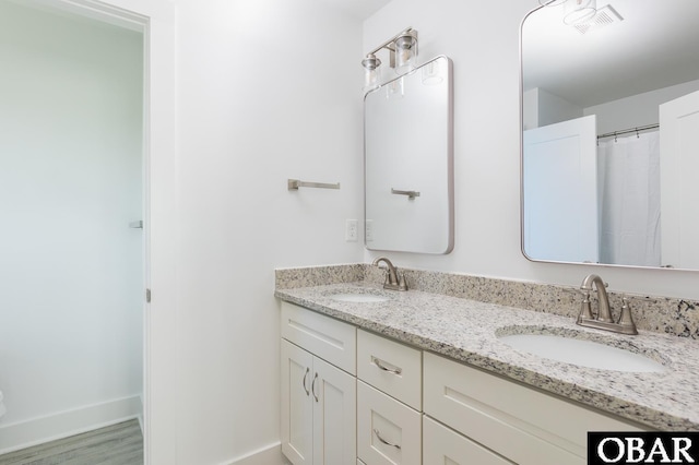 2267 Sandpiper Rd Lot 29, Corolla, NC 27927 - bathroom featuring double vanity, baseboards, and wood finished floors