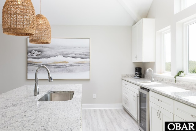 2267 Sandpiper Rd Lot 29, Corolla, NC 27927 - kitchen featuring beverage cooler, a sink, light wood-style flooring, white cabinets, and lofted ceiling