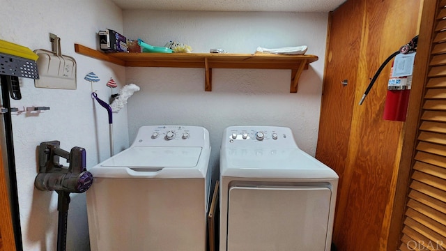 laundry room with laundry area, washer and clothes dryer, and a textured ceiling