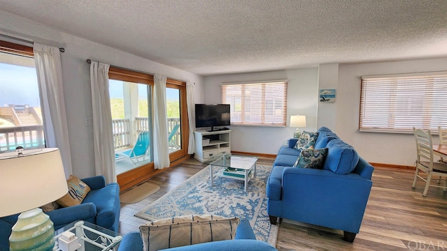 living area with a textured ceiling, wood finished floors, and baseboards