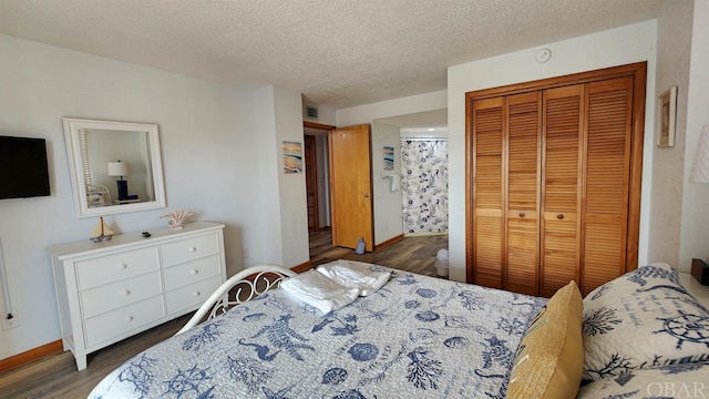 bedroom with a closet, visible vents, dark wood finished floors, and a textured ceiling