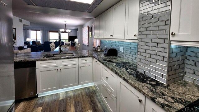 kitchen featuring stainless steel appliances, hanging light fixtures, a sink, and white cabinets