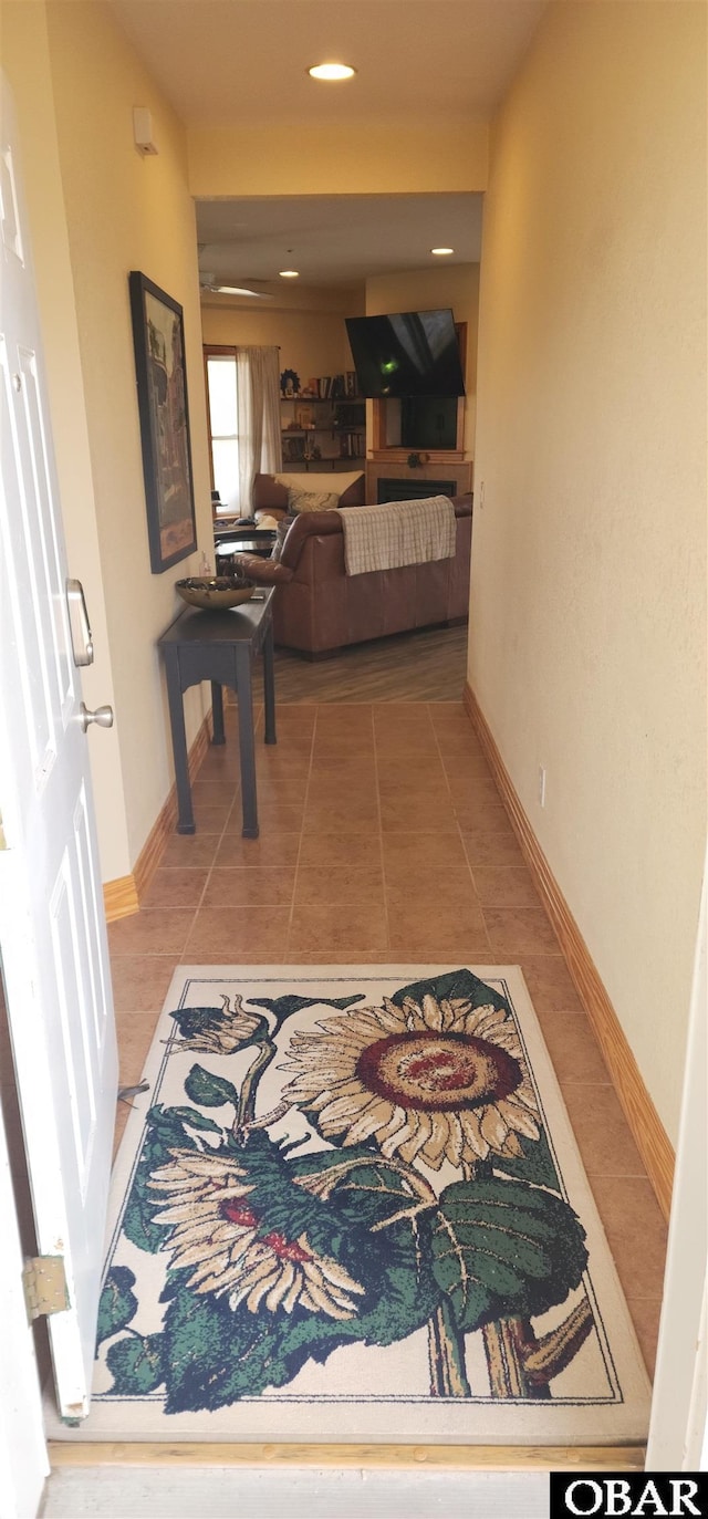 hallway featuring tile patterned flooring and baseboards