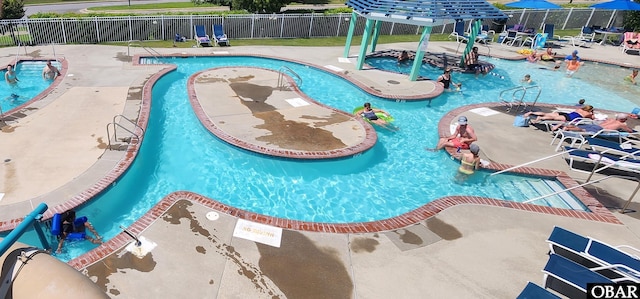 pool featuring a patio, fence, and a jacuzzi