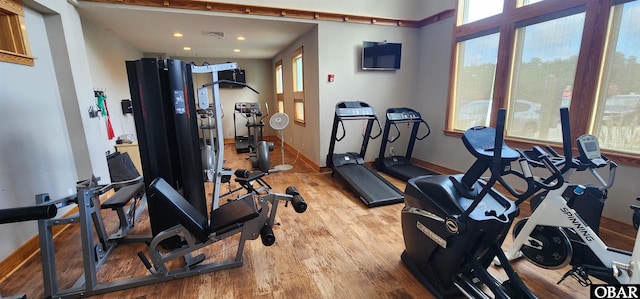 workout area featuring light wood-style floors, baseboards, and visible vents