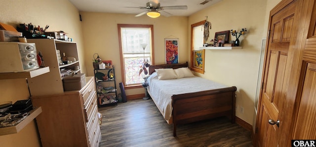 bedroom with visible vents, dark wood finished floors, baseboards, and ceiling fan