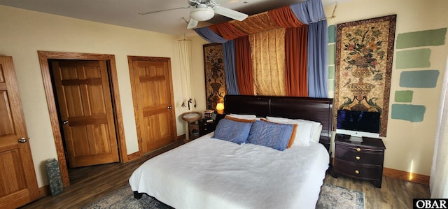 bedroom with dark wood-style floors, a ceiling fan, and baseboards