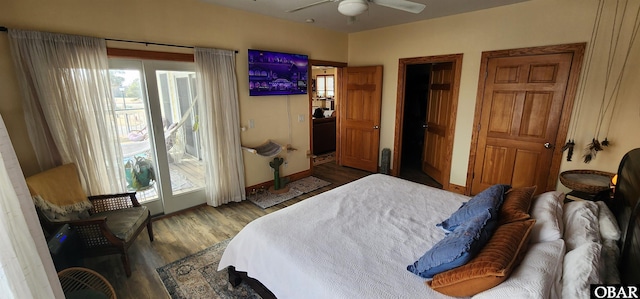 bedroom with access to exterior, multiple windows, ceiling fan, and wood finished floors