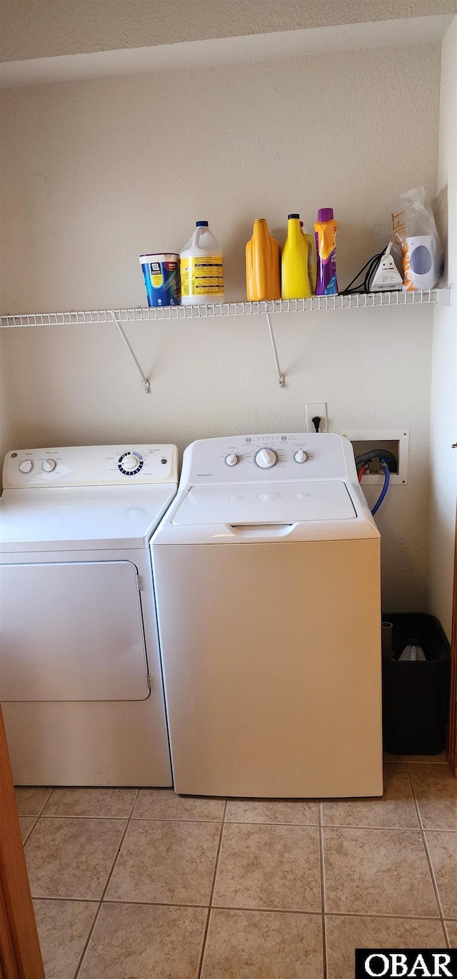 clothes washing area with laundry area, light tile patterned flooring, and independent washer and dryer