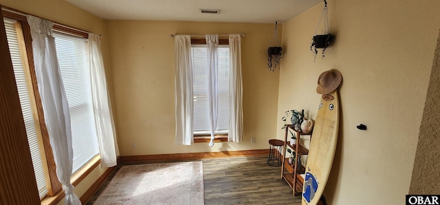 interior space featuring dark wood-style flooring, visible vents, and baseboards