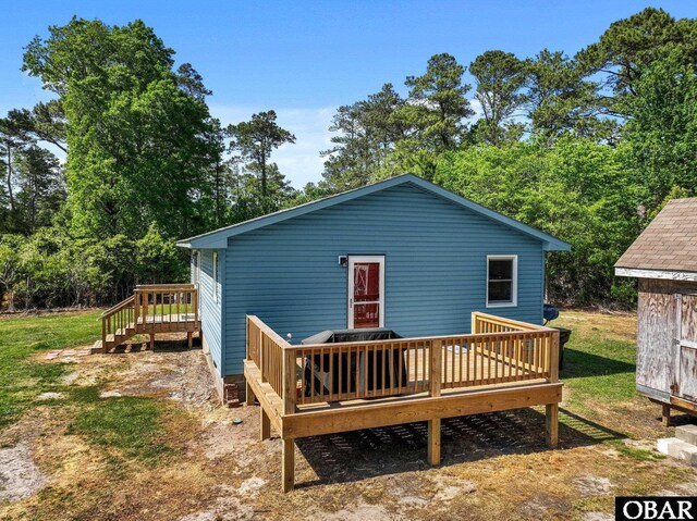 rear view of property featuring a wooden deck and view of wooded area